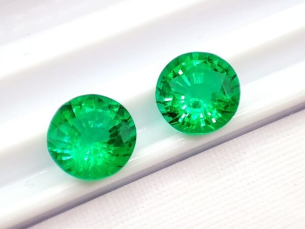 two green round cut lab emeralds 3.49 carats
