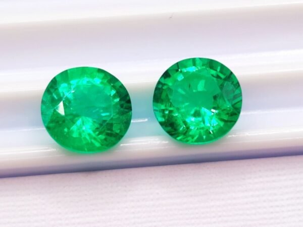 two green round cut lab emeralds 3.49 carats